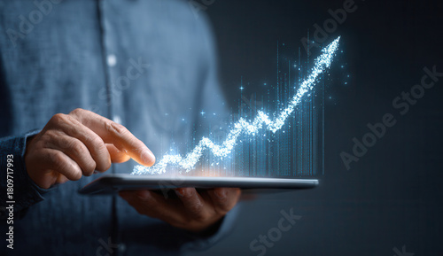 Smart device displays rising financial chart with glowing effects in dark environment during business analysis