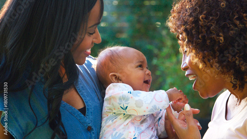 Grandmother With Adult Daughter And Baby Granddaughter Playing In Garden At Home Together