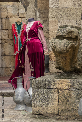National Dagestani women's dresses and ancient jugs near the walls of a stone fortress