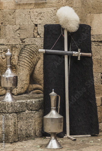 National Dagestani men's clothing, old jugs and a dagger near the walls of an ancient fortress
