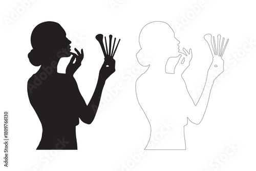 Silhouette of a woman applying makeup with brushes and a mirror reflection