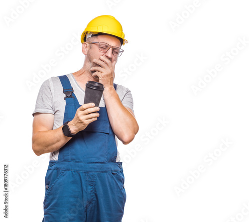Tired repairman, isolated on white background. Sleepy male with closed eyes holding coffee cup. Middle-aged construction worker covers face. Sleepy expression. Craftsman against white wall
