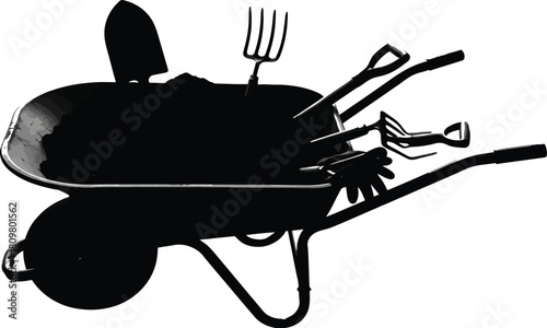 Dark wheelbarrow filled with soil and gardening tools, agriculture concept