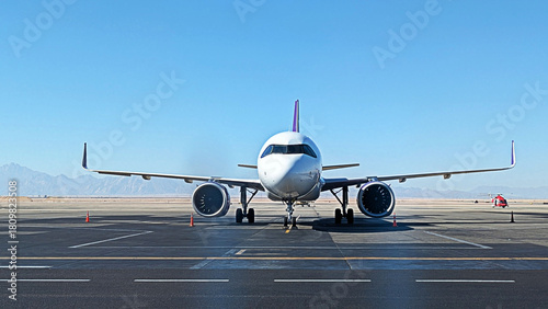 A modern passenger airplane on the tarmac at an airport on a clear day. Ready for travel.