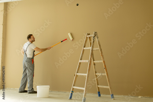 Man painting a wall in a ro...