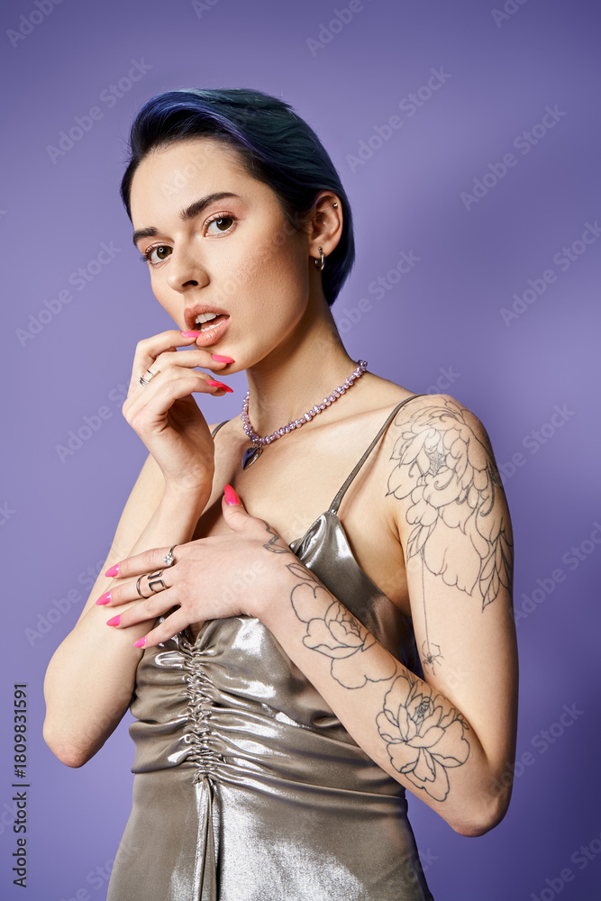 Obraz premium Stylish young woman with tattoos poses elegantly in vivid setting, showcasing contemporary fashion
