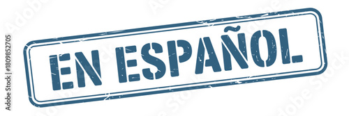 Distressed rectangle sign reads en espa ol in blue text