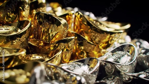 Gold and silver ingots pile, close-up shot, dark background, representing wealth and finance