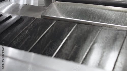Conveyor belt with moving suitcases in an airport. Concept airport efficiency and travel.