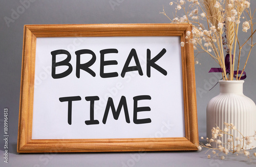 Break Time symbol. Concept words Break Time on beautiful wooden picture frame. Beautiful grey background with flower vase. Business and Break Time concept. Copy space.
