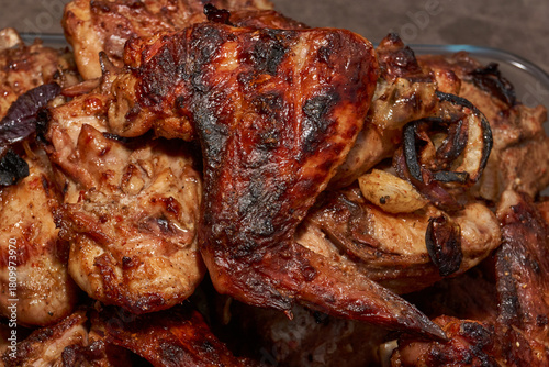 Juicy pieces of chicken were grilled in a metal grill over hot coals. The ruddy crust and smoky aroma emphasize the atmosphere of a picnic and a summer vacation in nature.