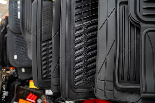 Close up of black rubber car floor mats on display.