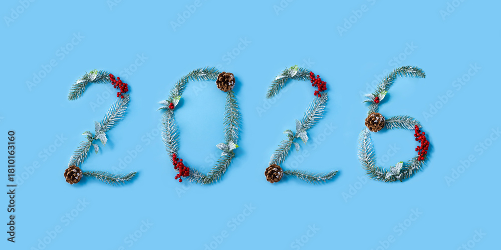 Fototapeta premium Numbers 2026 made from Christmas tree branches, cones and red berries. New Year calendar