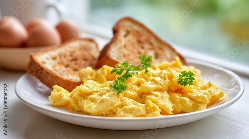 Delicious scrambled eggs with toast and parsley on a white plate, a classic breakfast dish that is both satisfying and nutritious