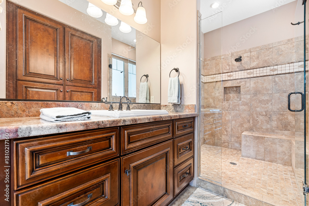 Fototapeta premium This is a bathroom featuring a sink, a mirror, and a walkin shower