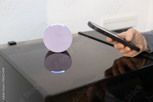 person controls smart wireless device with cell phone at home