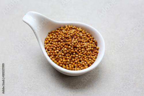 Brown coriander seeds on white background.