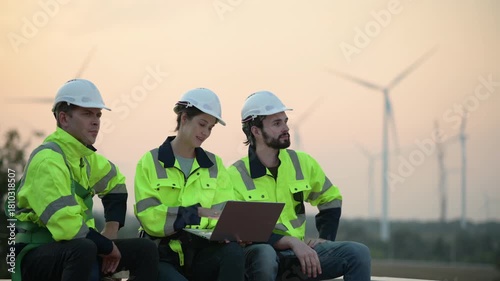 Team of engineers wearing safety helmets inspecting wind turbines at a wind farm. teamwork renewable energy, sustainable development, clean technology environmental engineering wind power generation.