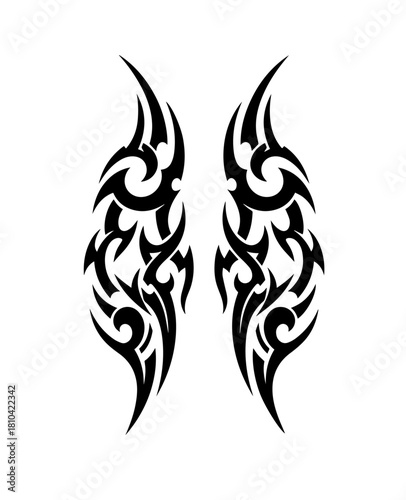 A pair of symmetrical black tribal tattoo designs features fluid, swirling curves and sharp, aggressive spikes that resemble stylized flames or abstract wings