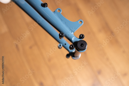 Close up of a bicycle frame rear dropout area showing mounting points of thro axel, bolts, and flat mount brake interface.