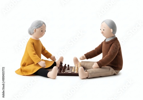 Stuffed dolls of an elderly couple sitting on the floor and playing chess, symbolizing strategy, mental agility, and retirement leisure