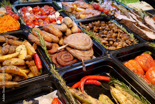Sausages and frankfurters, fried potatoes, vegetables. Various foods