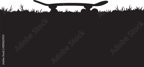 Black silhouette of skateboard on grass white