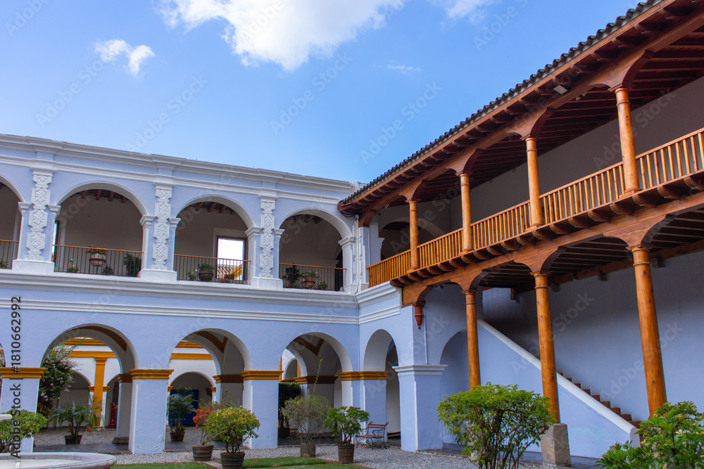 Fototapeta premium Historic colonial courtyard in Antigua Guatemala elegant white arches warm wooden balconies Spanish style architecture and open sky creating a serene blend of colonial and natural