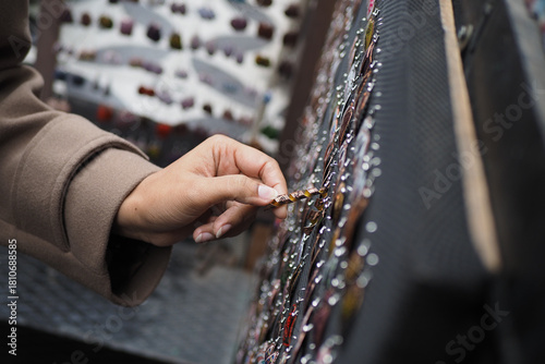 Fototapeta Naklejka Na Ścianę i Meble -  Hand selecting a colorful pin at a market stall