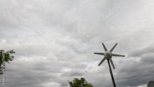 Small Wind Turbine Rotating Under Cloudy Scottish Highlands Sky