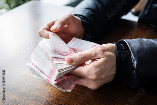 Close-up of hands counting Chinese 100 yuan banknotes. Financial deal in China. Cash payment and financial transaction concept.