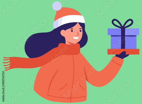 Girl in an orange winter jacket smiling while holding a blue gift box on a green background, celebrating the joy of giving during the holiday season with happiness and warmth.