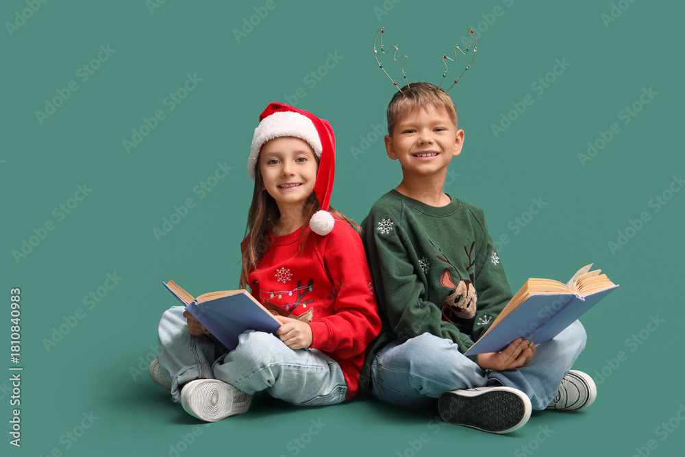Naklejka premium Cute little children reading Christmas story on green background