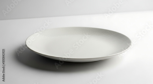 Elegant white ceramic plate on a clean white surface, perfect for food presentation.