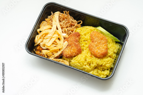 Bild auf Leinwand an Indonesian Nasi Kuning (Yellow Rice) take-out meal featuring bright turmeric