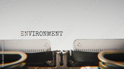 Old mechanical typewriter typing Environmental Hazard in a close-up view, with metal letters striking the white paper.