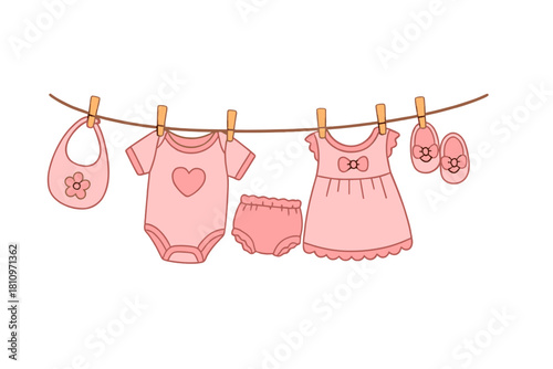 Pink newborn baby girl clothes drying on a rope clothesline with pins