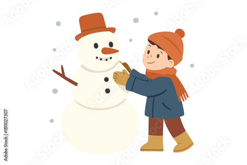 Cheerful young boy putting the finishing touches on a classic snowman during winter season