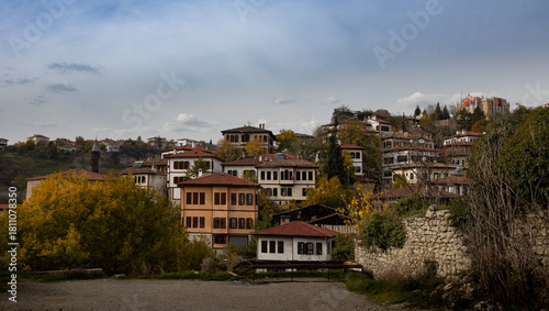 Historic Safranbolu houses set on a hillside with autumn colors and traditional architecture under a calm sky.