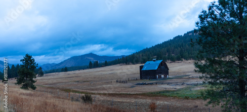 Panoramic view of old barn in the middle of farm in autumn blue hour