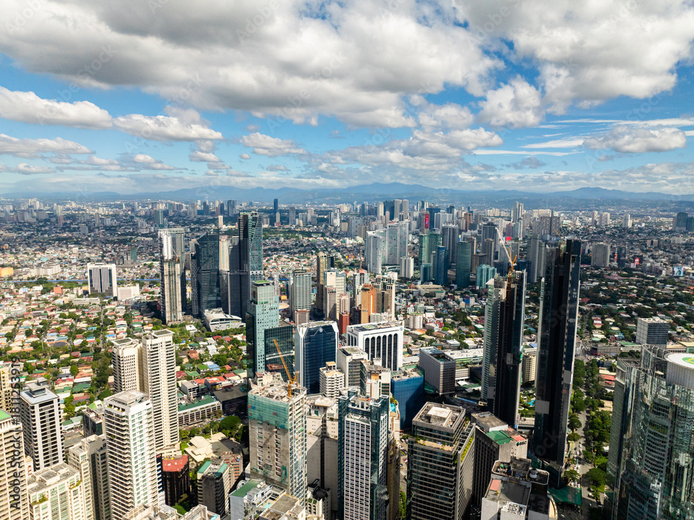 Obraz premium Business office buildings and high rise towers in Makati. Blue sky and clouds. Metro Manila, Philippines.