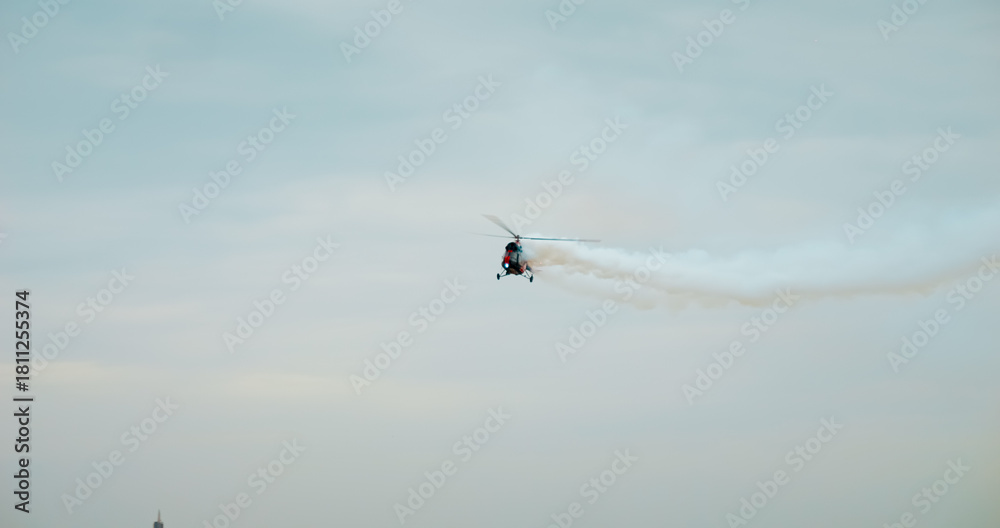 Fototapeta premium HeliForce MI-2 helicopter makes a cloud of smoke in an air show. Bucharest Air Show BIAS 2024.