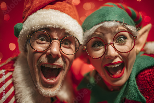 Full size photo of excited two people santa claus elf dancing enjoying midnight party wearing eyeglasses eyewear hat headwear spectacles isolated over red background