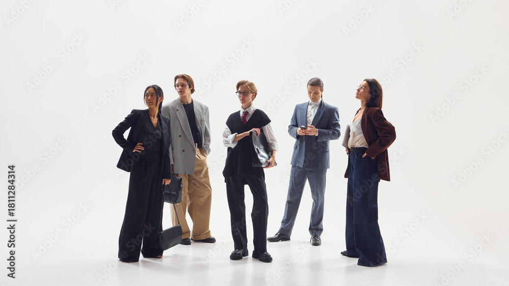 Obraz premium Mixed gender team of stylish professionals standing together in contemporary office fashion. Concept of collaboration, equality, innovation in business and lifestyle media.