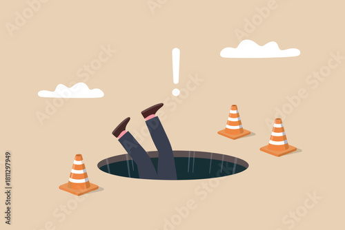 Businessman's legs from hole, warning cones and exclamation mark illustrate unexpected business pitfall or accident