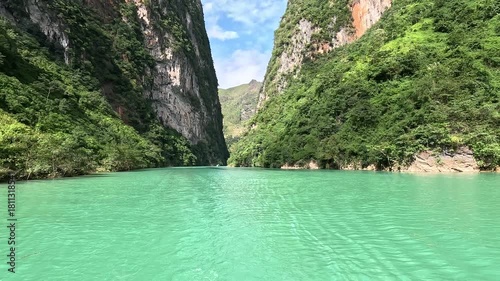 The Nho Que River flows between steep karst mountains in Ha Giang, Vietnam. Turquoise water, narrow canyon walls, and dramatic scenery create a stunning and immersive travel footage.