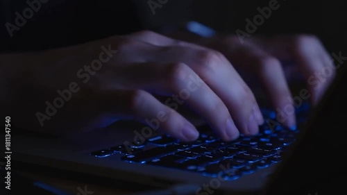 Typing fast on a laptop in the dark, coding or working late, a digital lifestyle concept