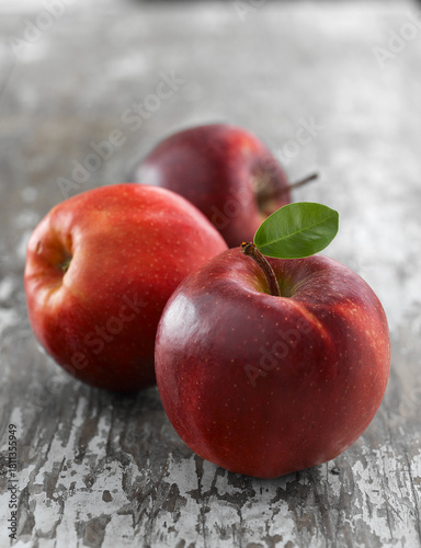 Three fresh red apples including Jonagold and Red Delicious varieties