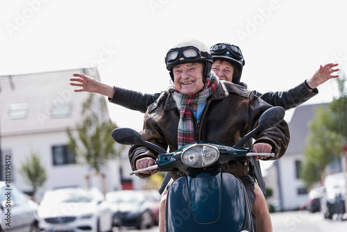Smiling couple riding scooter outdoors having fun together