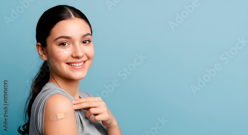 Smiling woman with a bandage on her arm after vaccination
